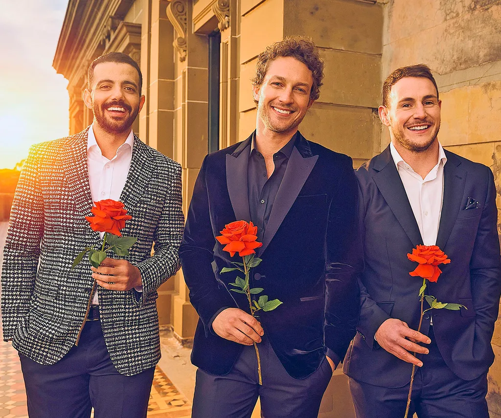 Luke Bateman (right) alongside fellow Bachelors Wes (left) and Ben (middle) posing with roses in suits for 2023 season of The Bachelors.