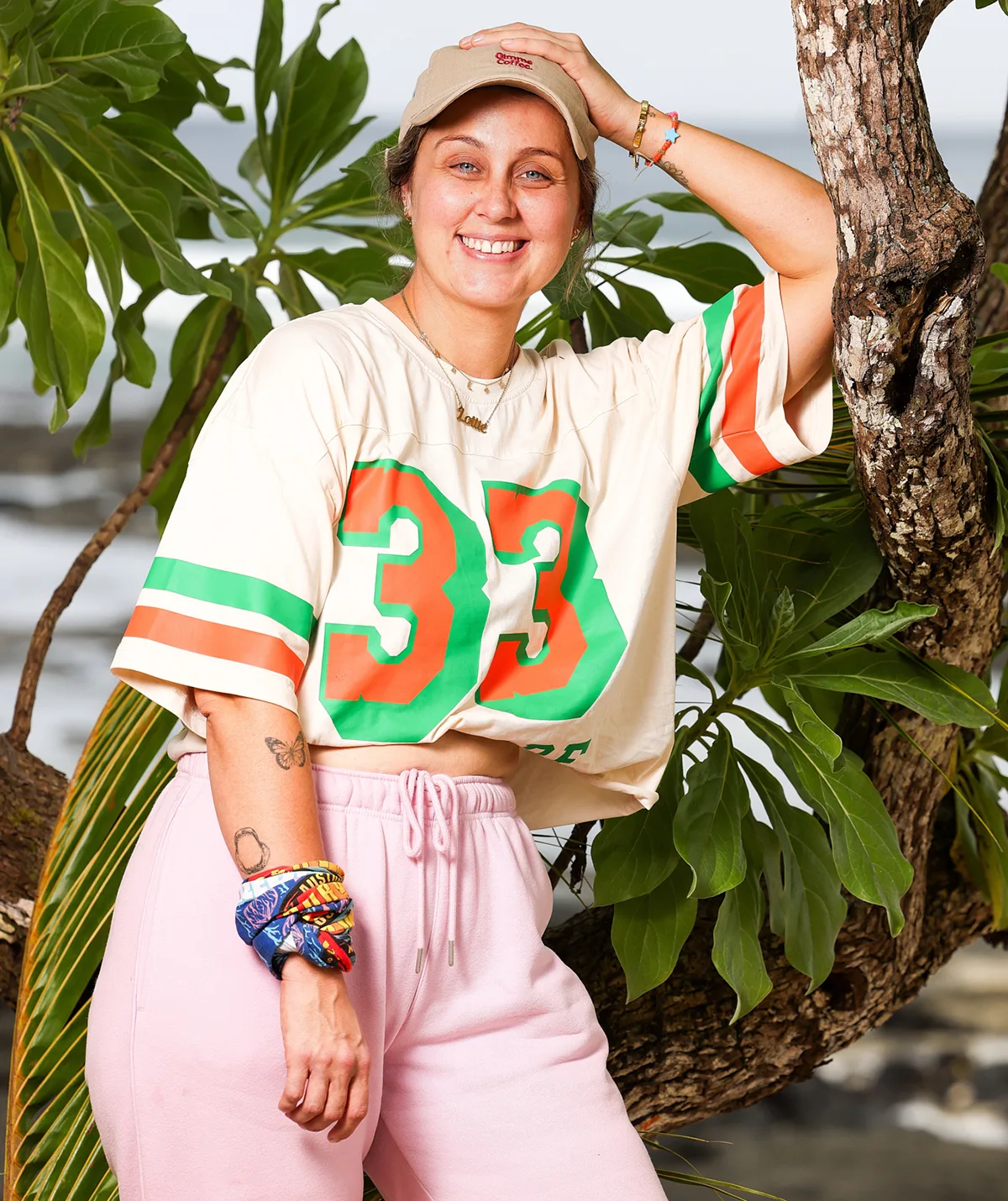 Lottie, wearing pink pants and a top with the number 37, stands with her hand on her head