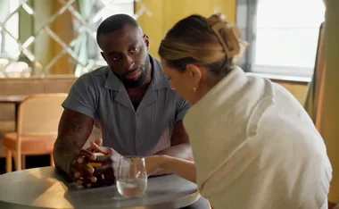 David from MAFS sits across from fellow bride Bec in a bar at a table, during the Feedback Week challenge.