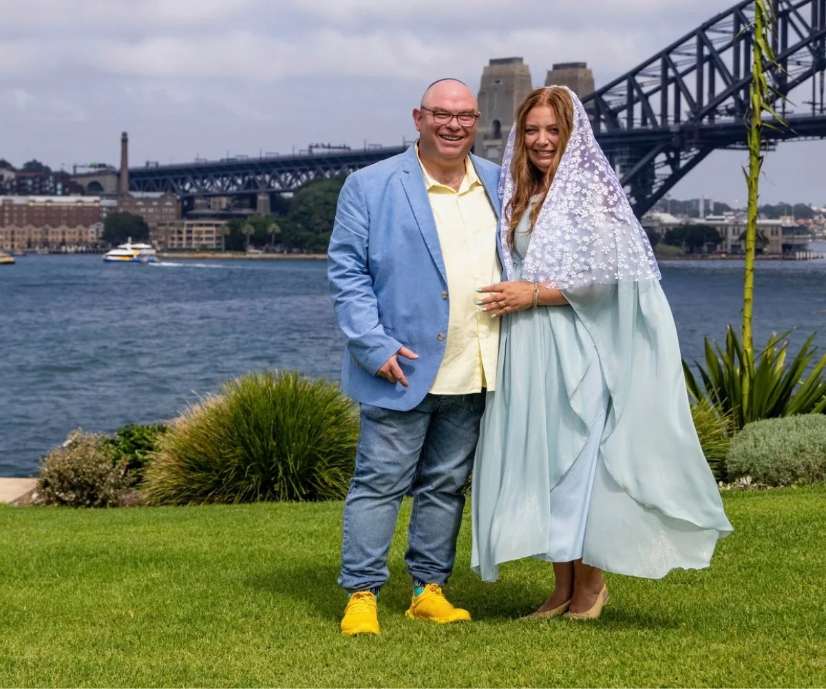 A couple in wedding clothes in front of the Sydney harbour bridge.