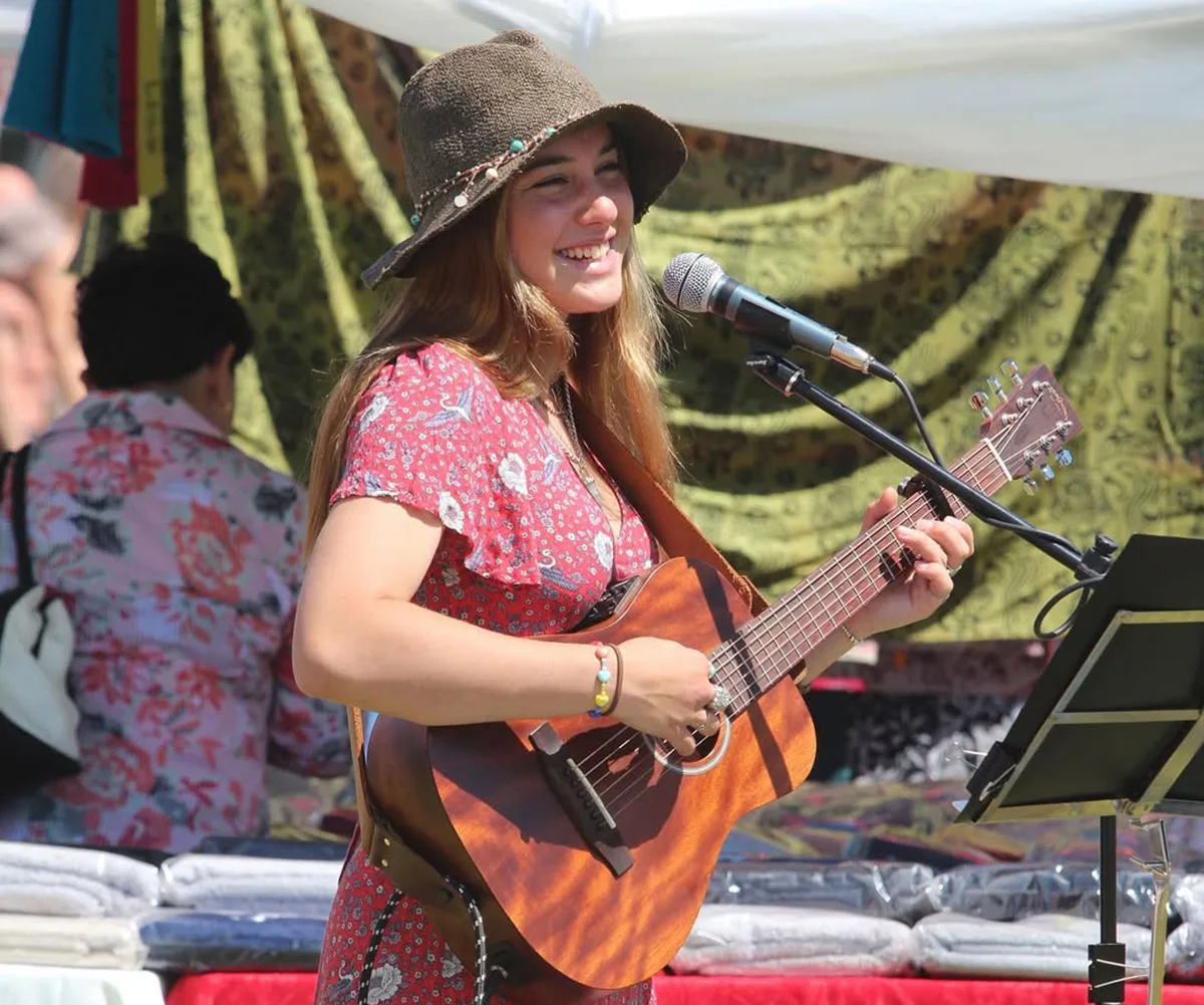 Kesha on stage playing her guitar.