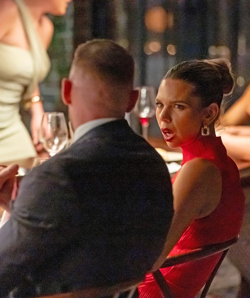 Bec in a red dress at the MAFS dinner party looking at her husband Danny.