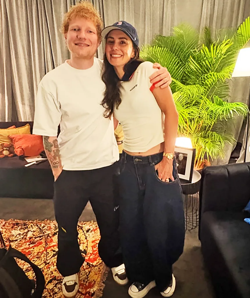 Ed Sheeran and Amy Shark pose smiling and hugging each other.