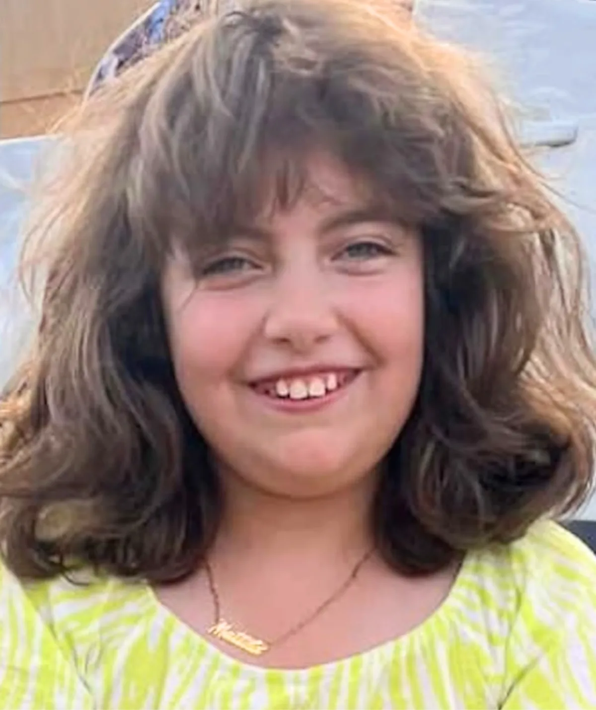 A young girl smiling in yellow
