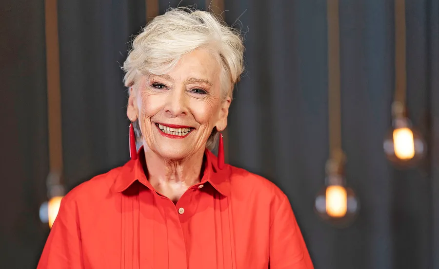 Maggie Beer in the MasterChef Australia 2026 kitchen smiling in a red dress.