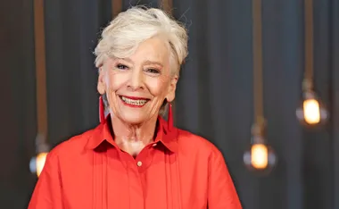 Maggie Beer in the MasterChef Australia 2026 kitchen smiling in a red dress.
