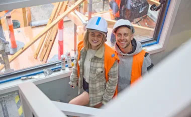 Julia and her husband on site of My Reno Rules in their house mid renovations.
