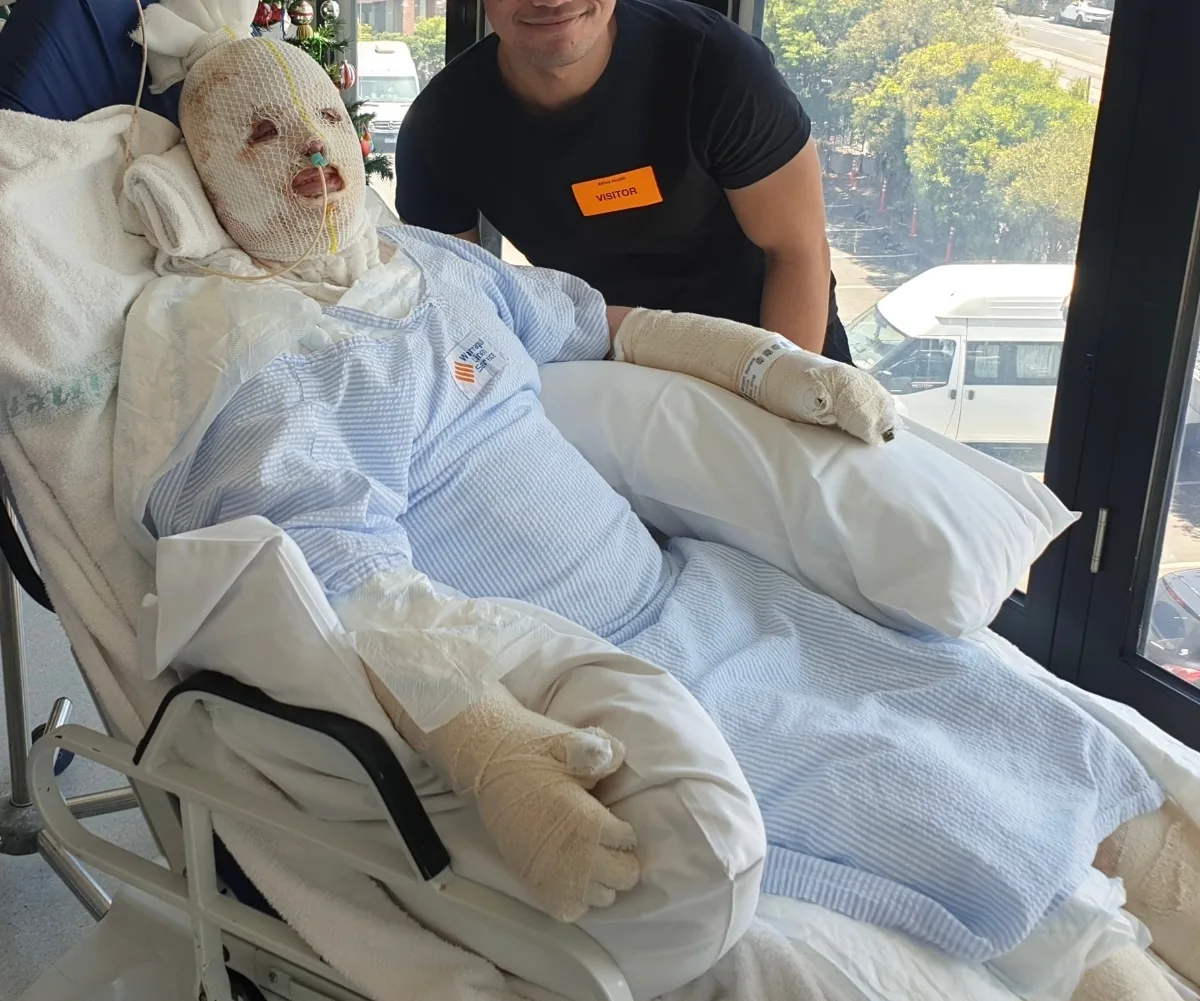 A woman in a hospital bed covered with bandages