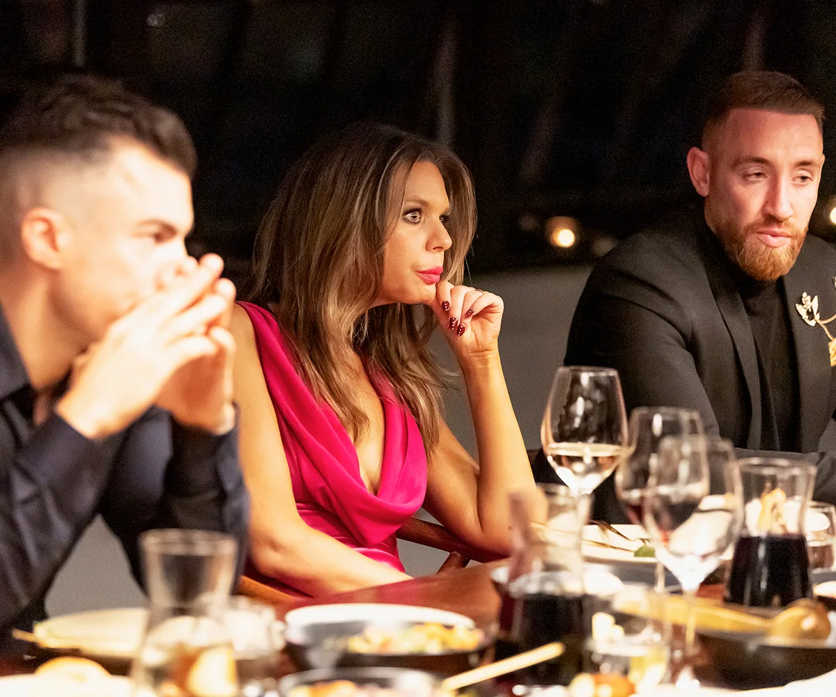 Bec in a red dress sitting at the MAFS dinner party in between Filip and husband Danny.