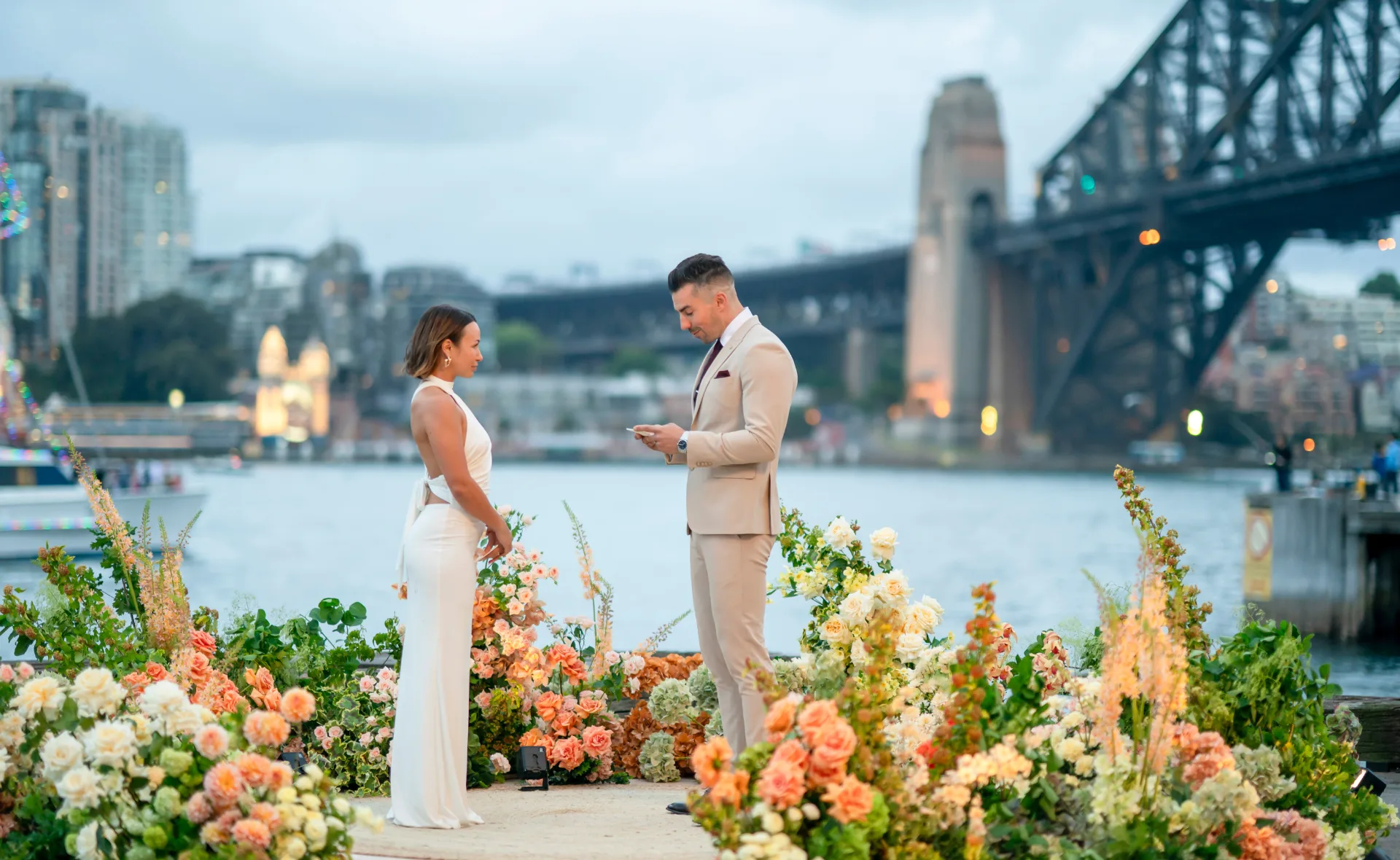 MAFS' Stella and Filip at their final vows ceremony, standing in a white dress and beige suit, the pair are pictured in front of Sydney harbour bridge.