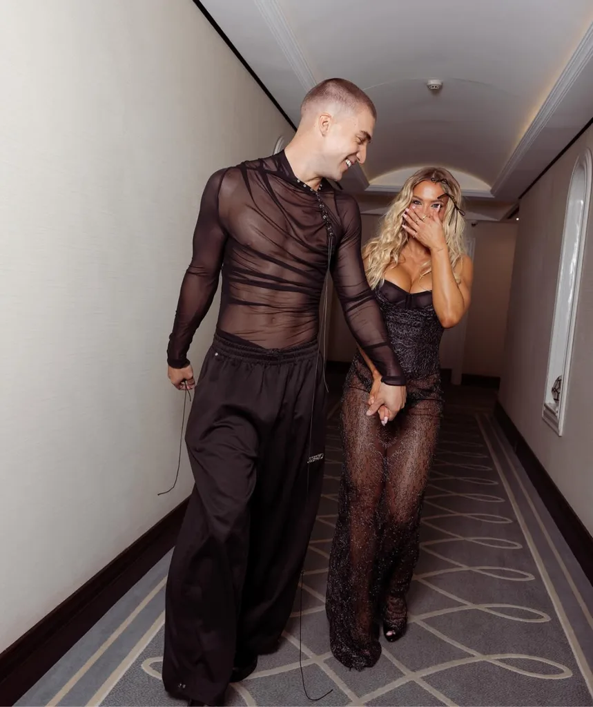 Tammy Hembrow and new boyfriend Grayson Te Moana walking down a hallway dressed in all black together.