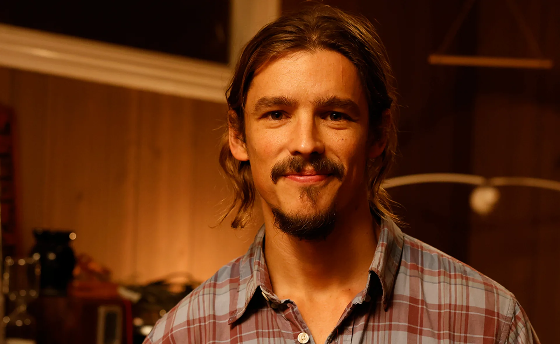 Brenton, wearing a checked shirt, in character