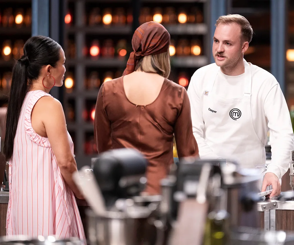 Casper Kenworthy talking to Sofia Levin and Poh Ling Yeow in the MasterChef Australia kitchen.