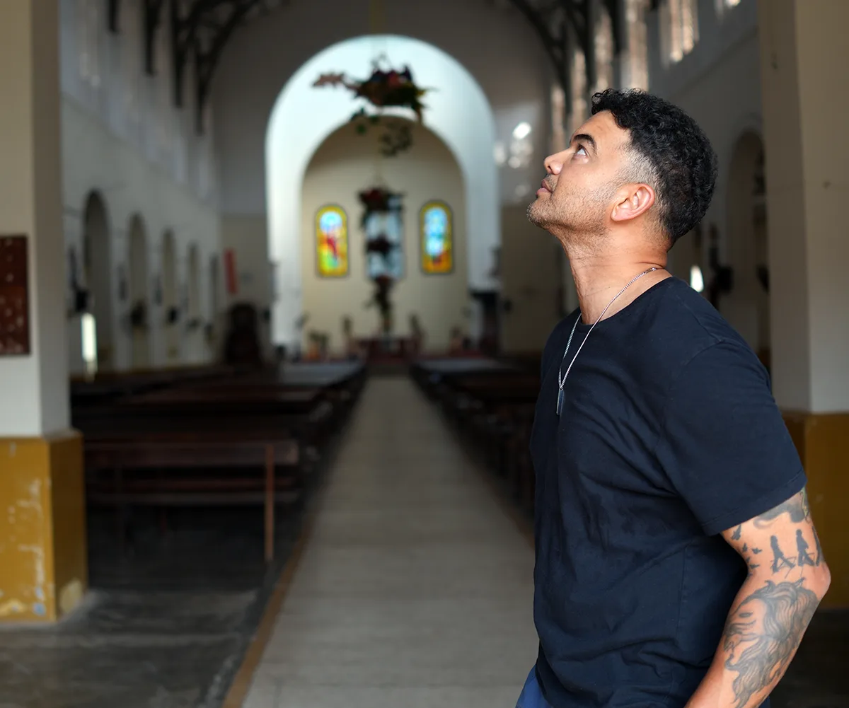 Guy stands in a cathedral, looking up