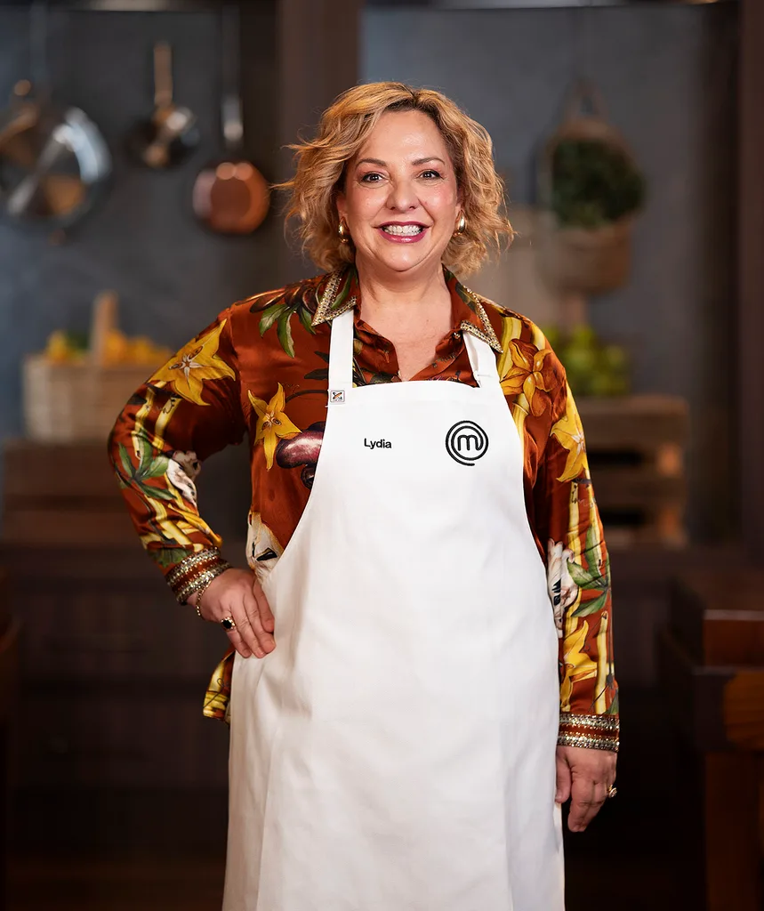 Lydia Kamperos standing in the MasterChef Australia kitchen smiling.