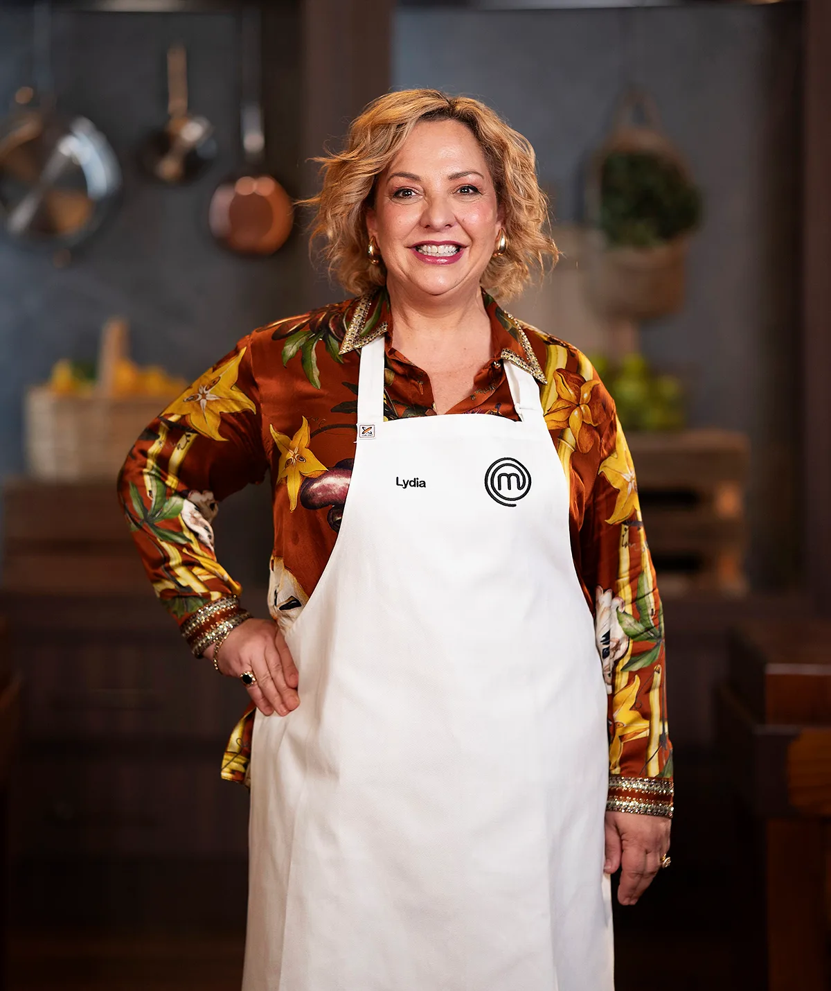 Lydia Kamperos standing in the MasterChef Australia kitchen smiling.