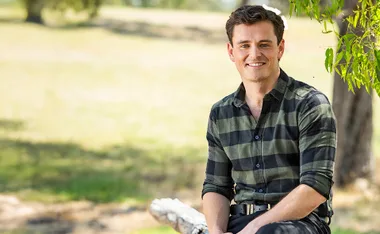 Alex, in a checked shirt, at his farm