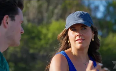Maddison, with a cap on, speaks to Alex