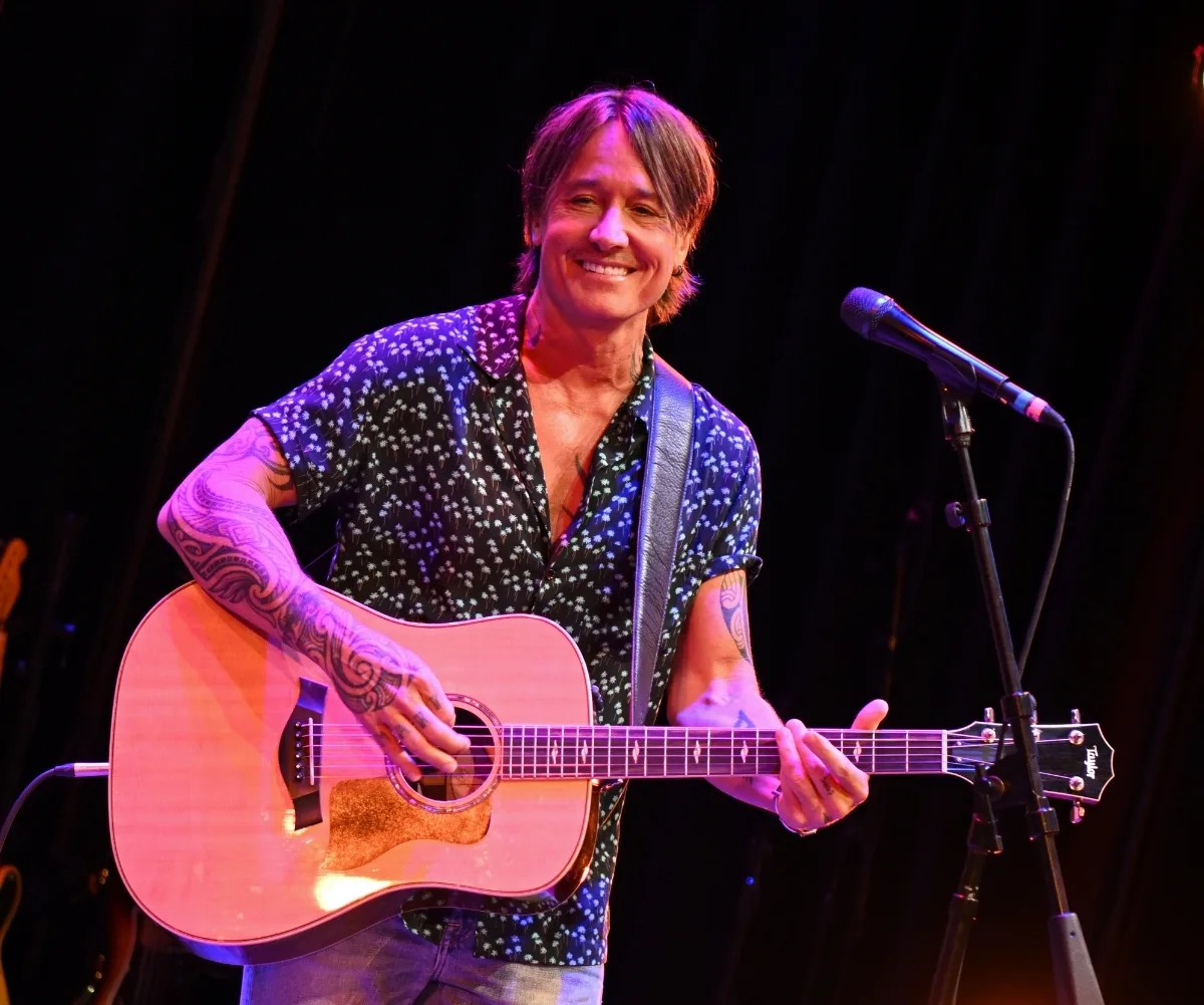 A man plays the guitar.