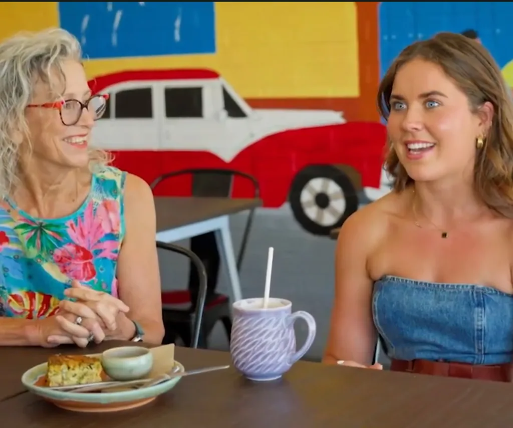 Maddison sits next to Alex's mum in a cafe