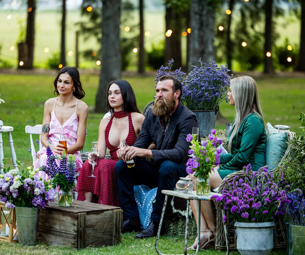 Jason and three of his ladies sit in chairs on a grassy area