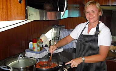 Lisa Mead preparing dinner in the galley of the motor yacht she was cheffing on in the British Virgin Islands. (Image: Supplied)