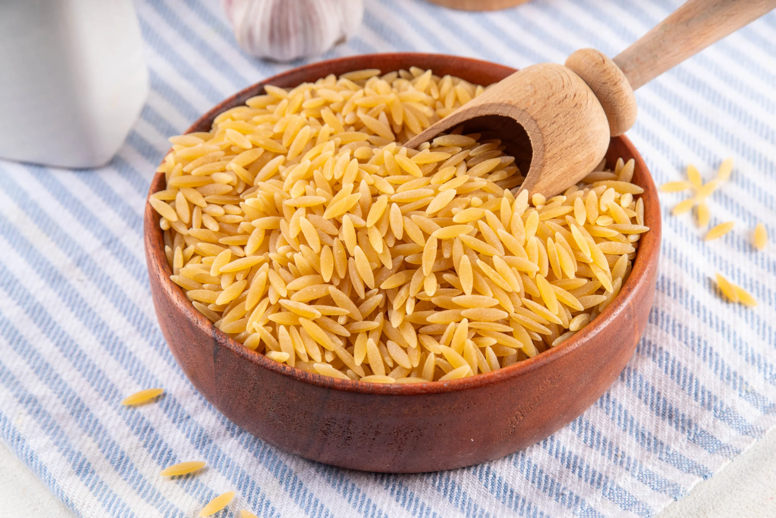 Raw uncooked orzo pasta, Italian dry pasta risoni orzo in bowl on table, copy space