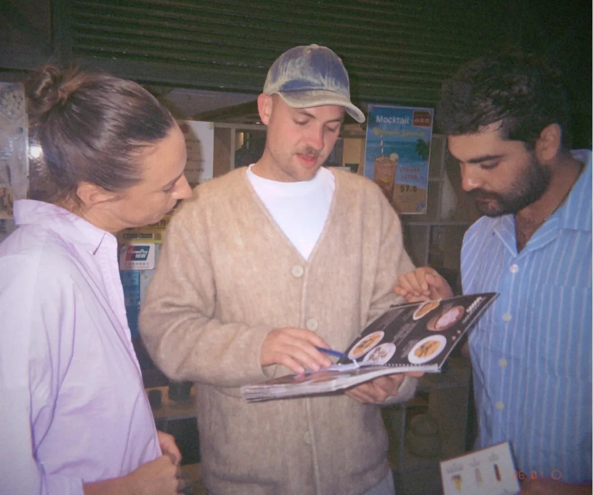 Annabel, Casper and Vinnie from MasterChef Australia reading a menu. 