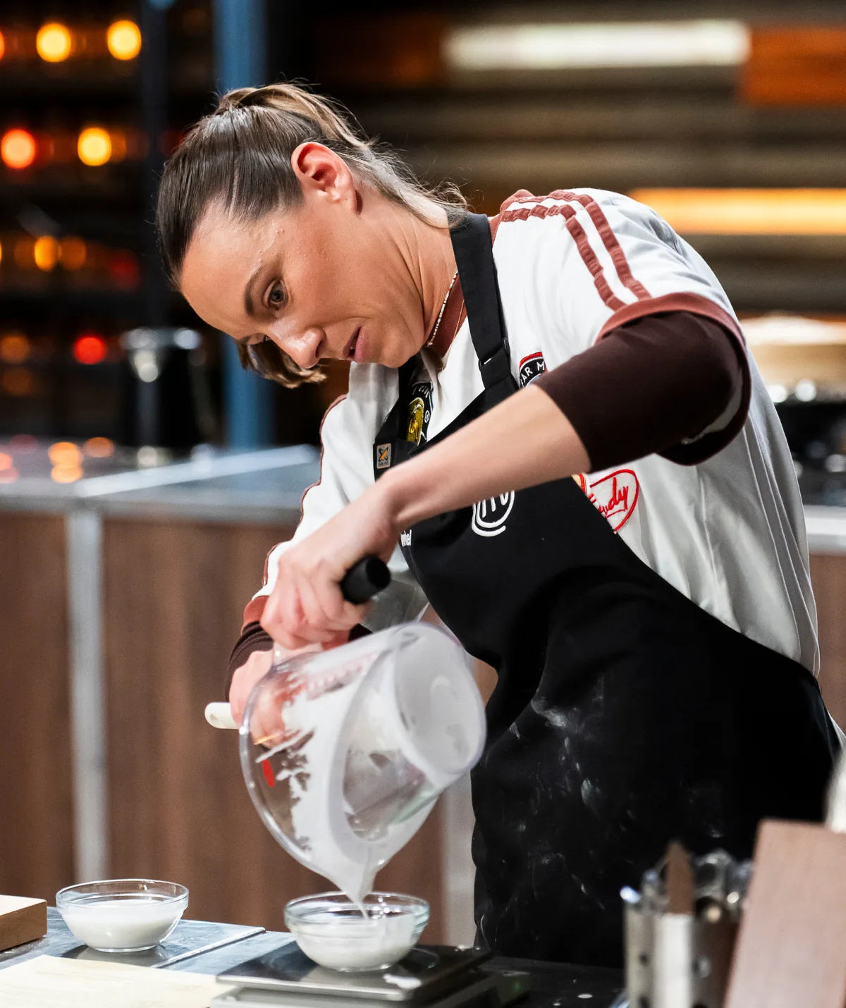 Annabel Lloyd pouring ingredients in the MasterChef Australia kitchen.