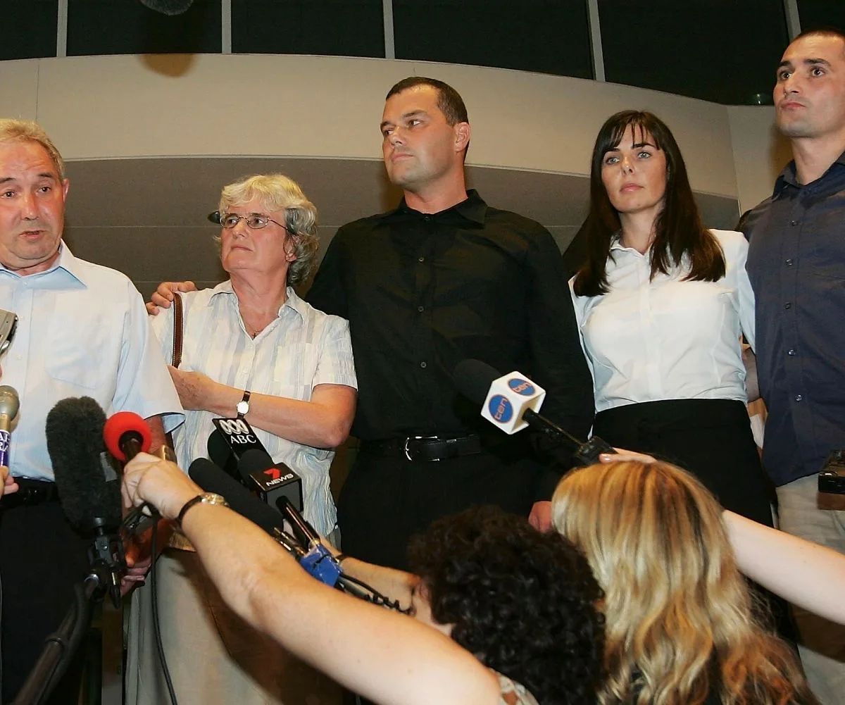 A family gather in front of news reporters