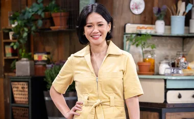 Natalie, in a yellow dress, stands on the set of The Voice