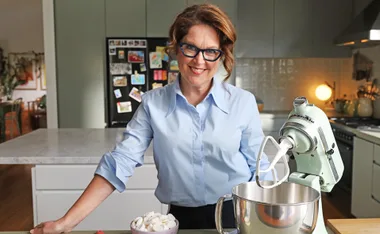 Annabel leans on a kitchen bench next to a mixer