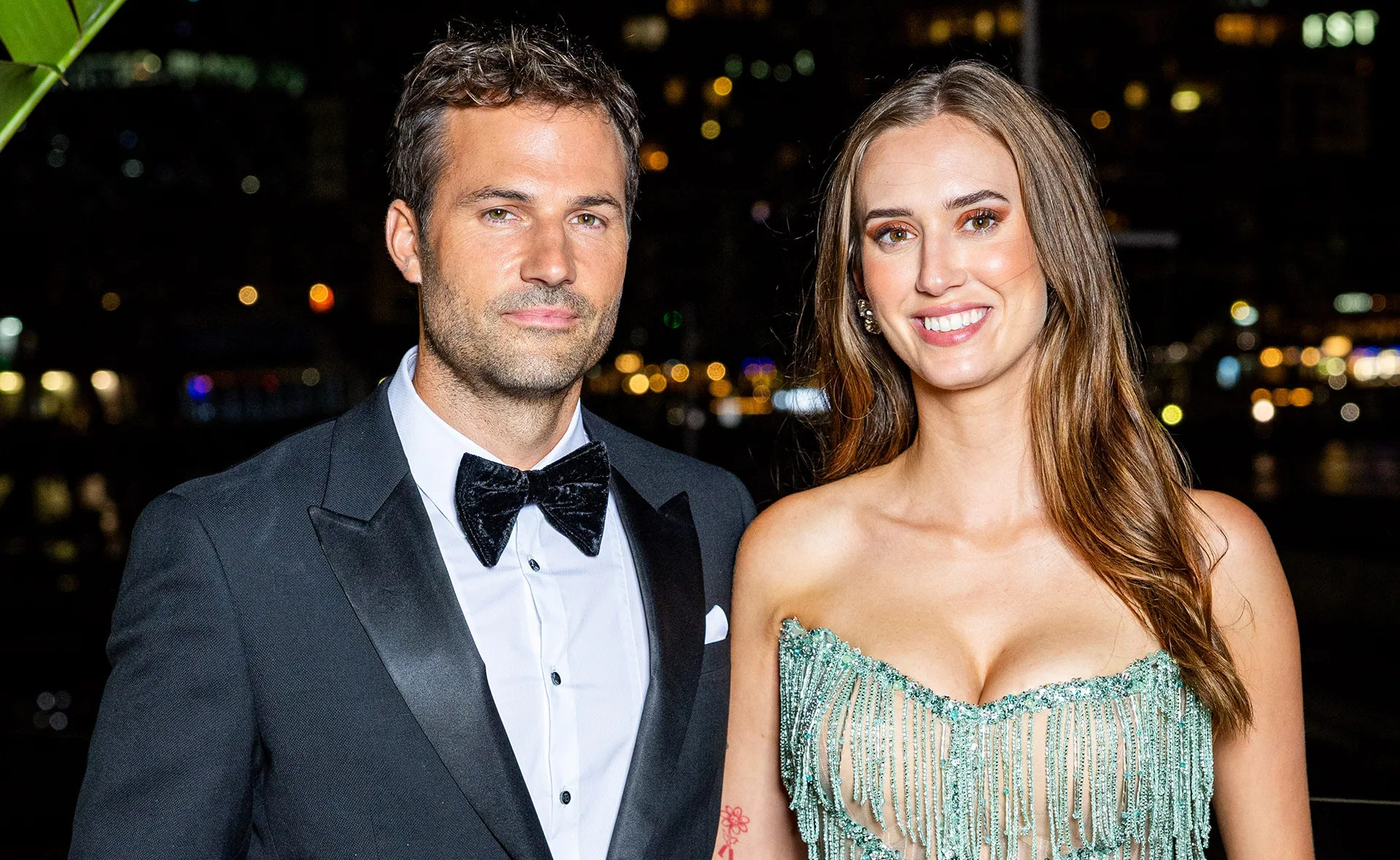 Jarrad, dressed in a black-tie outfit, stands next to Yvonne, wearing a shiny evening gown