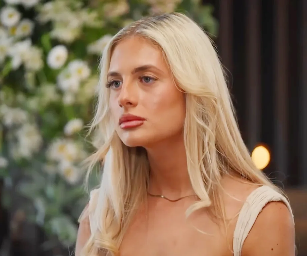 Scarlett, wearing white, listens intently