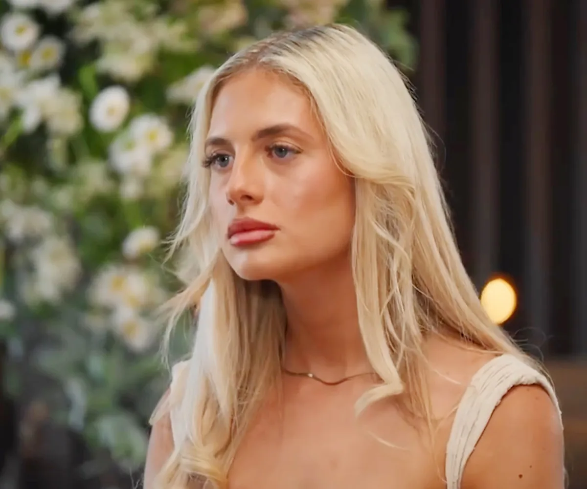 Scarlett, wearing white, listens intently