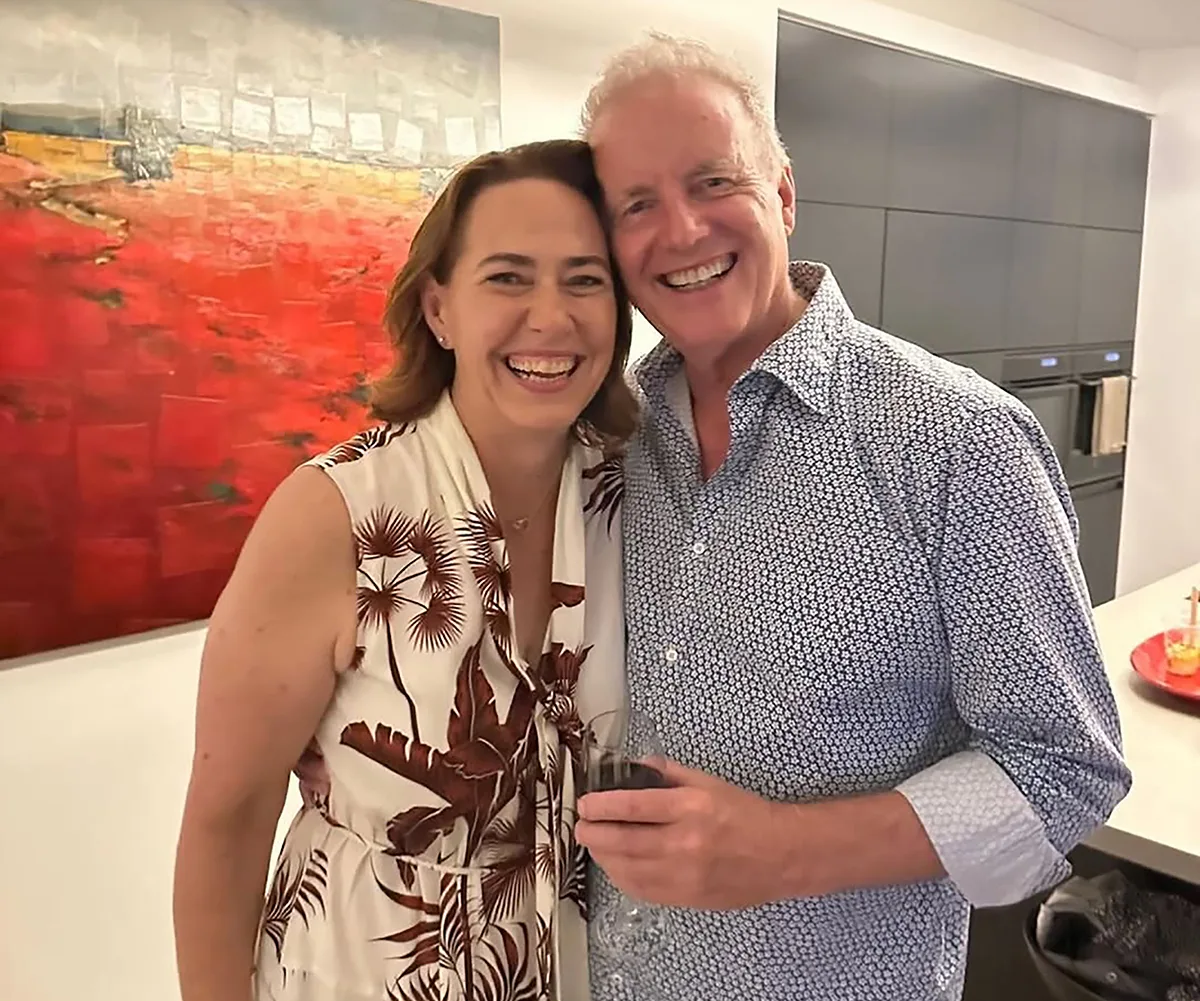 Lisa stands next to Simon, both smiling