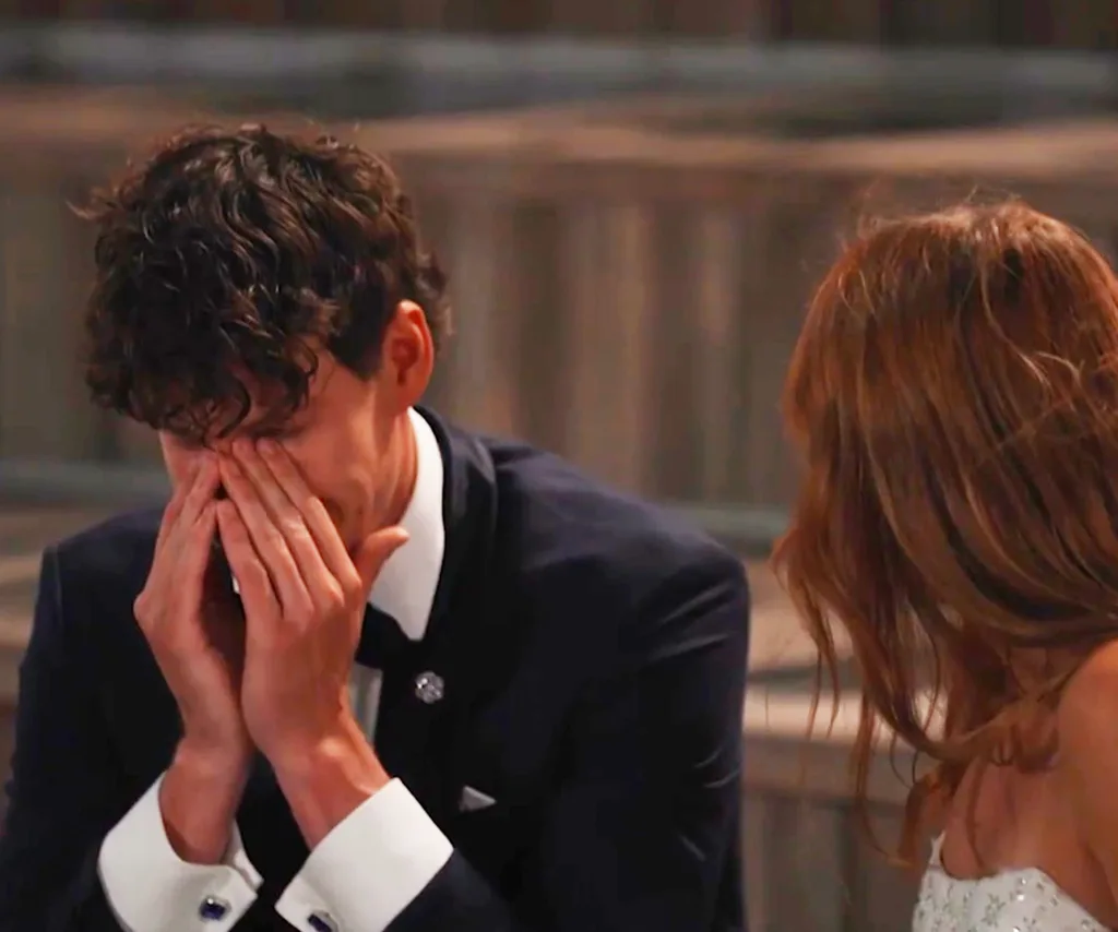 Zac, sitting next to Grace, covers his face with his hands