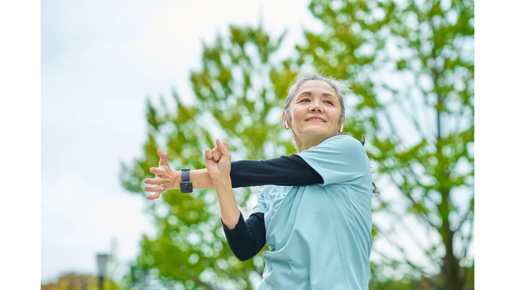 An older woman stretches before a run.