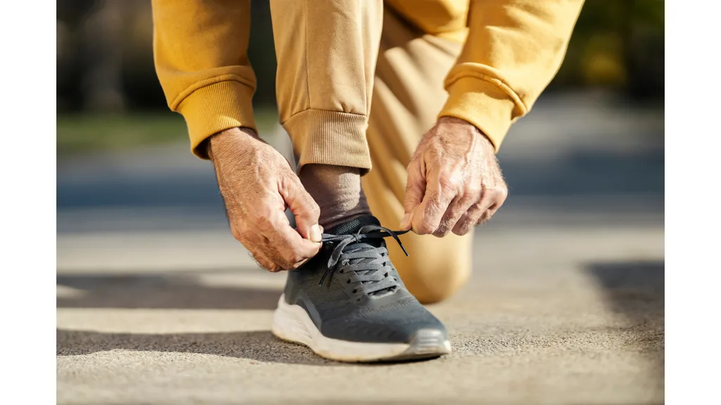 A man ties up the shoelaces on his running shoes.