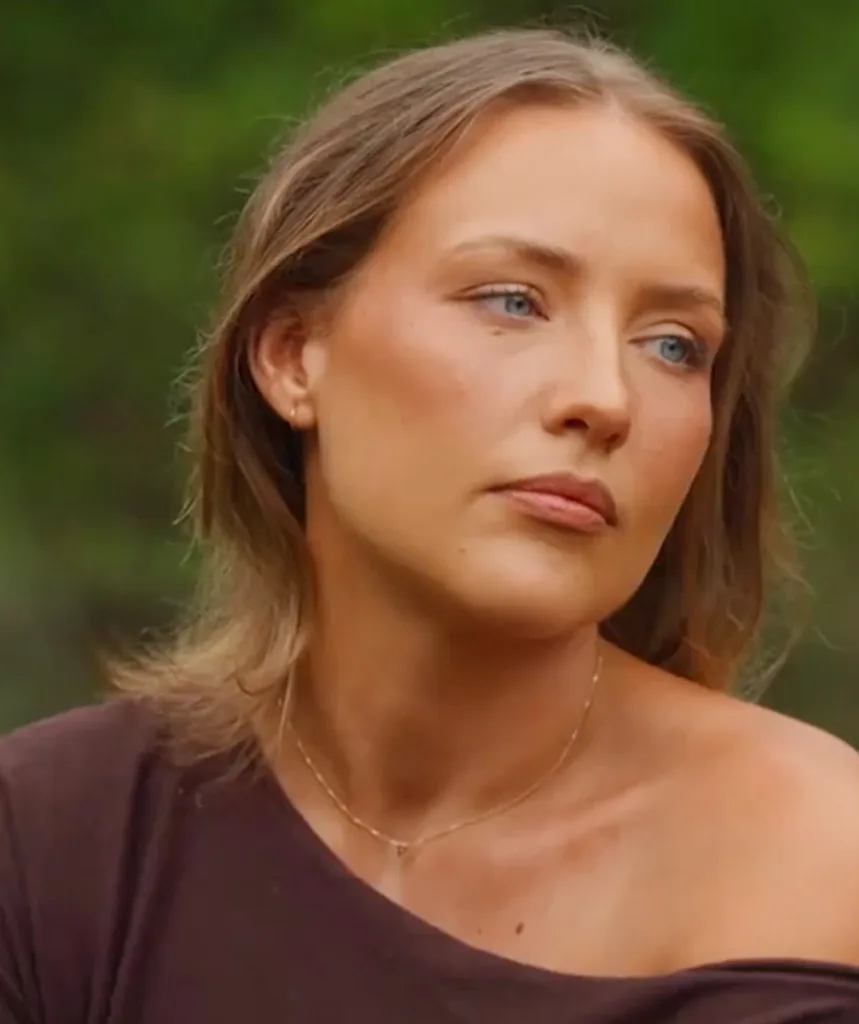 Rachel, wearing a brown top, sitting outside
