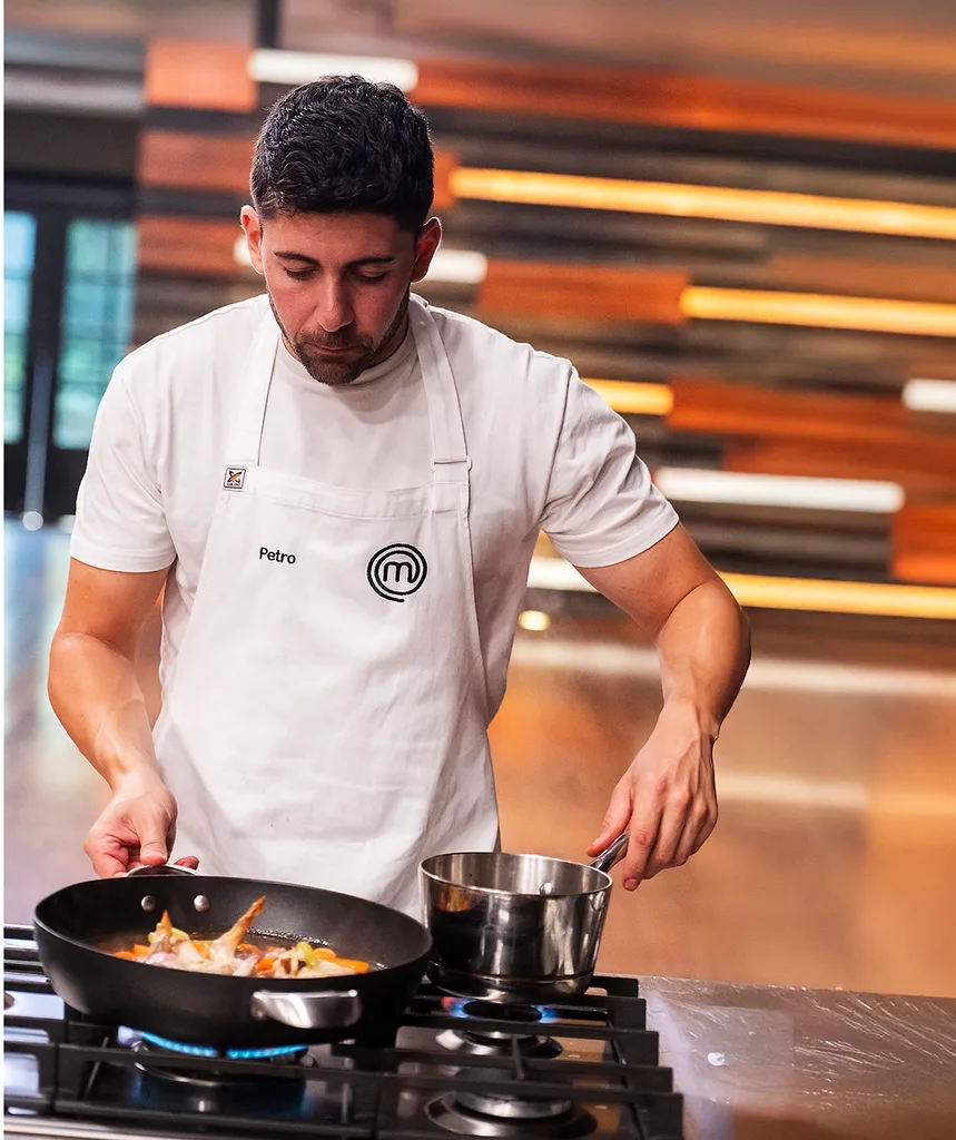 Petro Papathomas in the MasterChef Australia kitchen cooking over a pan.