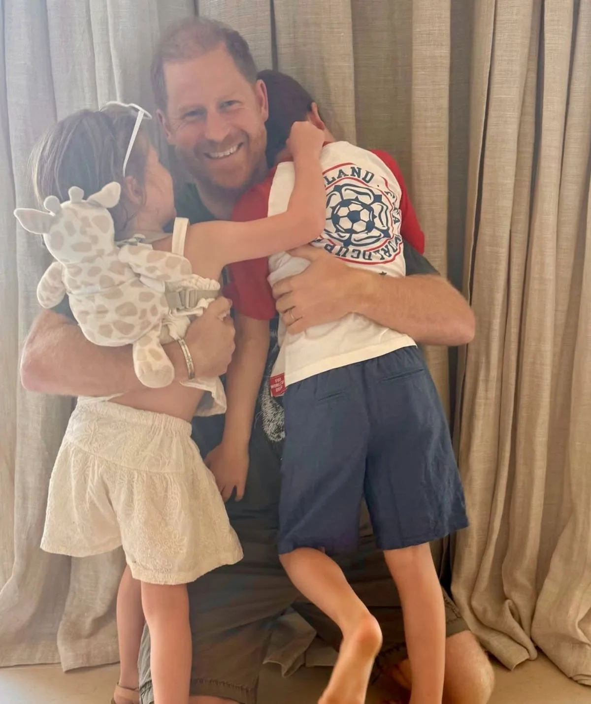 Prince Harry hugging his two children