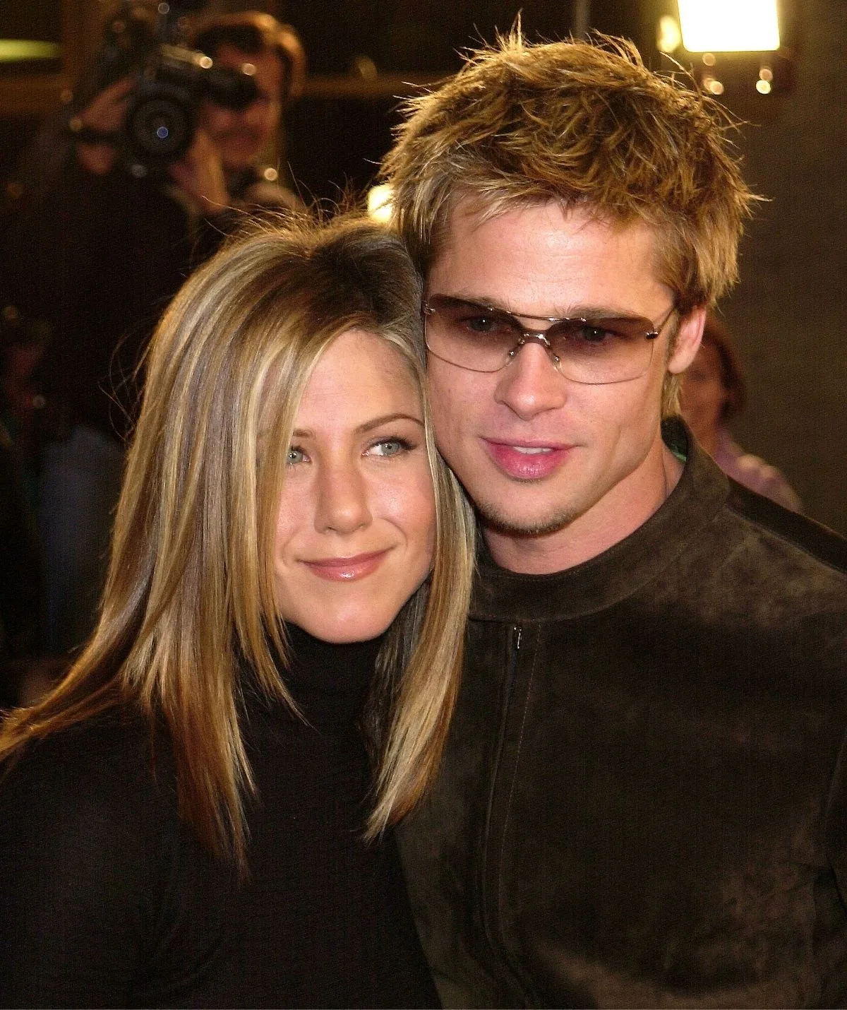 Jennifer Aniston and Brad Pitt cuddling next to each other