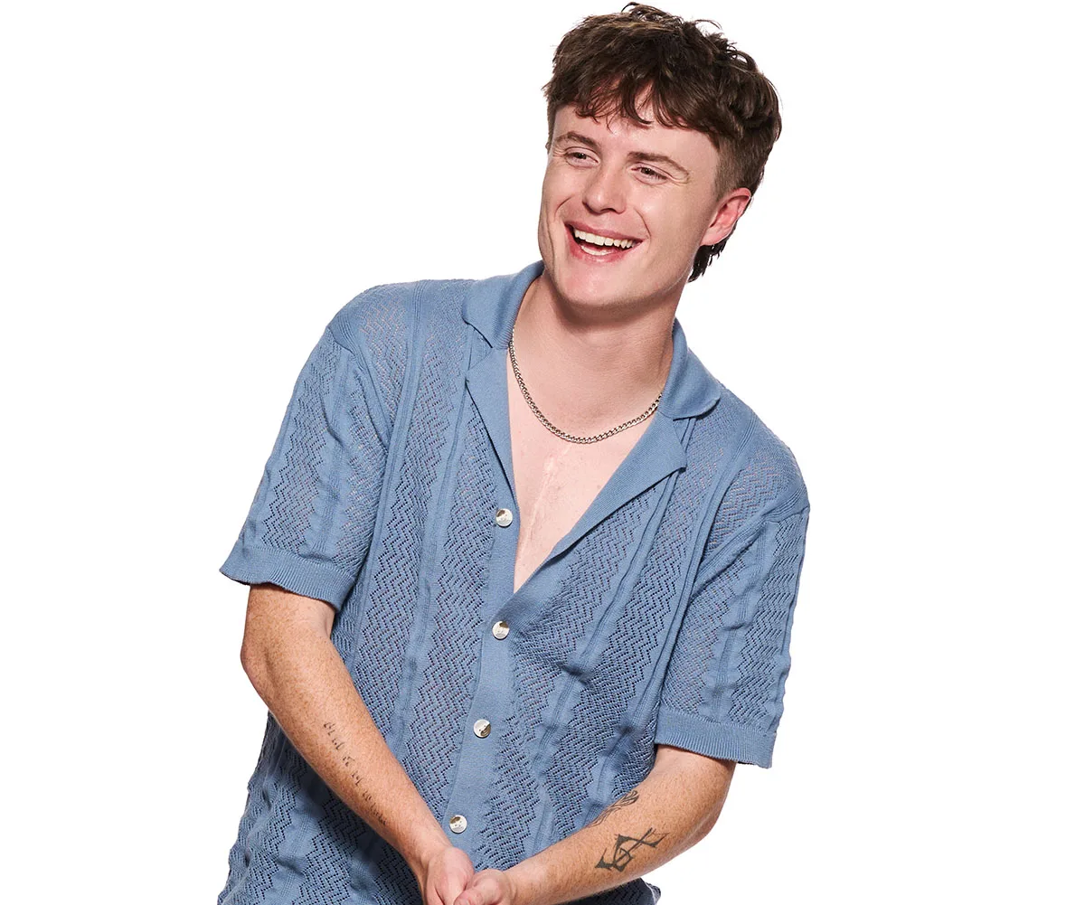 Findlay, wearing a blue shirt in front of a white background