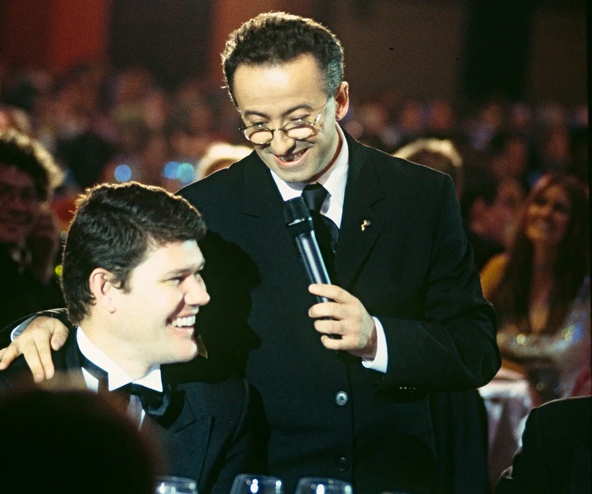 Andrew Denton stands next to a seated James Packer