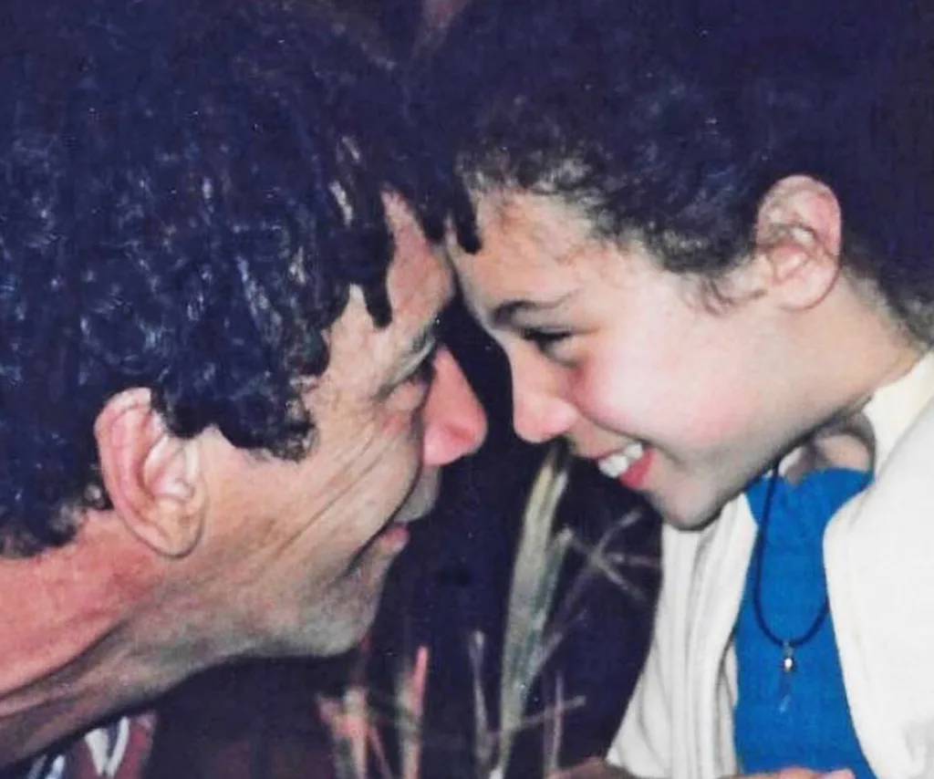 In an old photo, Mark Williams is looking into the eyes of his daughter Taylor, as a child