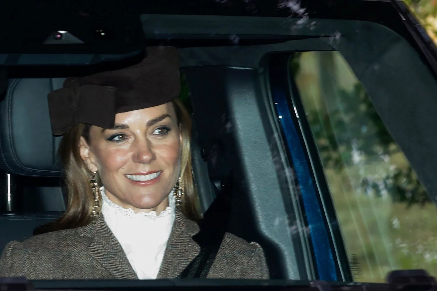 Kate, Princess of Wales, smiles as she is driven to church by her husband Prince William