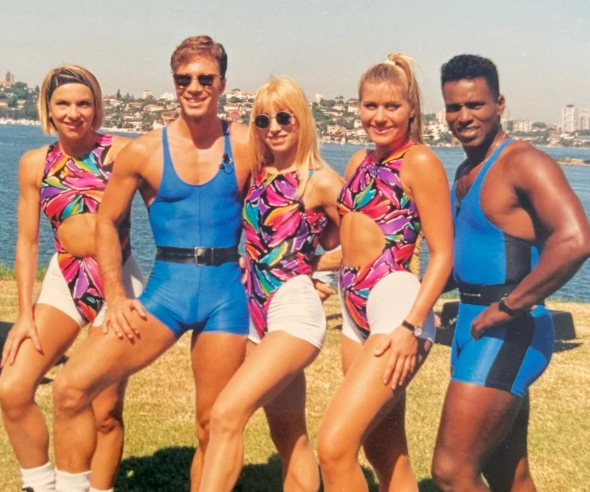 Aerobics Oz Style instructors pose with beach as backdrop