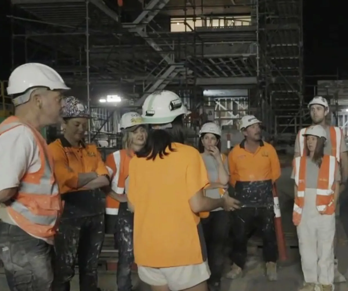 Tayla speaking to all the contestants on site of The Block at a body corporate.