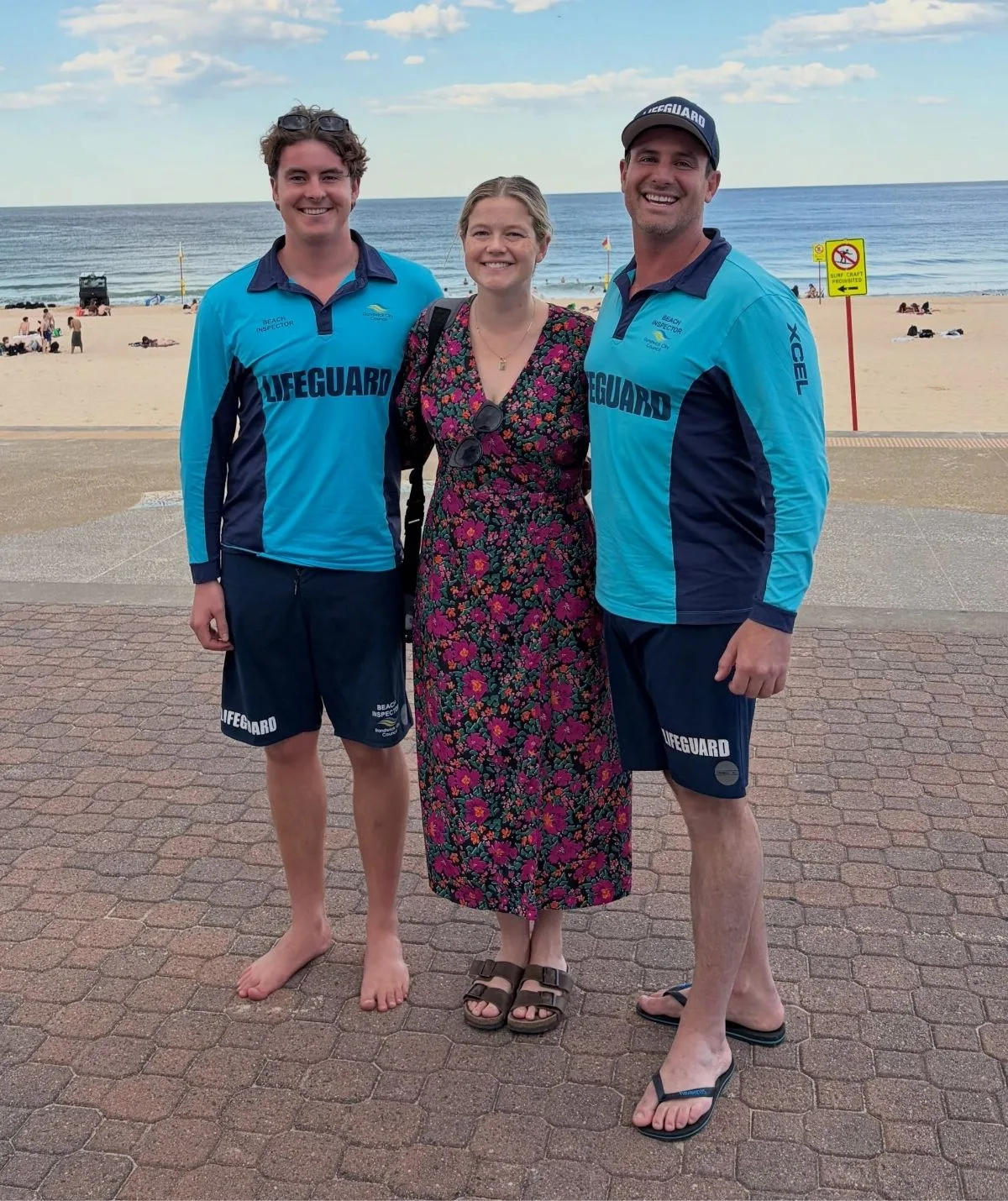 Leah Stewart smiles with lifeguards at the beach 